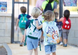 Un grupo de niños se dirige a su colegio en este primer día de clase.