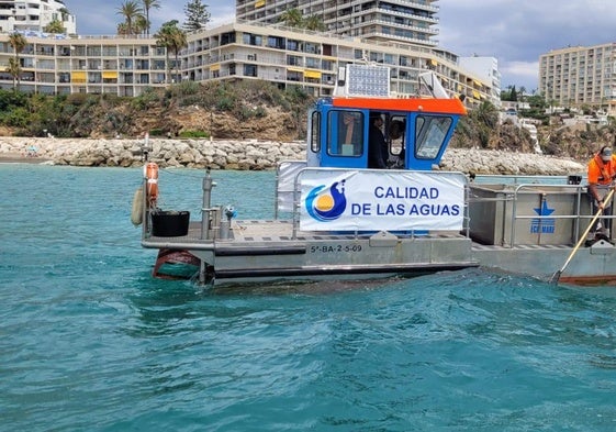 Uno de los barcos encargados de la limpieza de las aguas, frente a El Morro de Torremolinos.