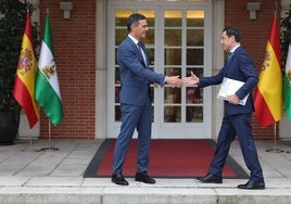 Pedro Sánchez recibe al presidente andaluz a las puertas del Palacio de La Moncloa.