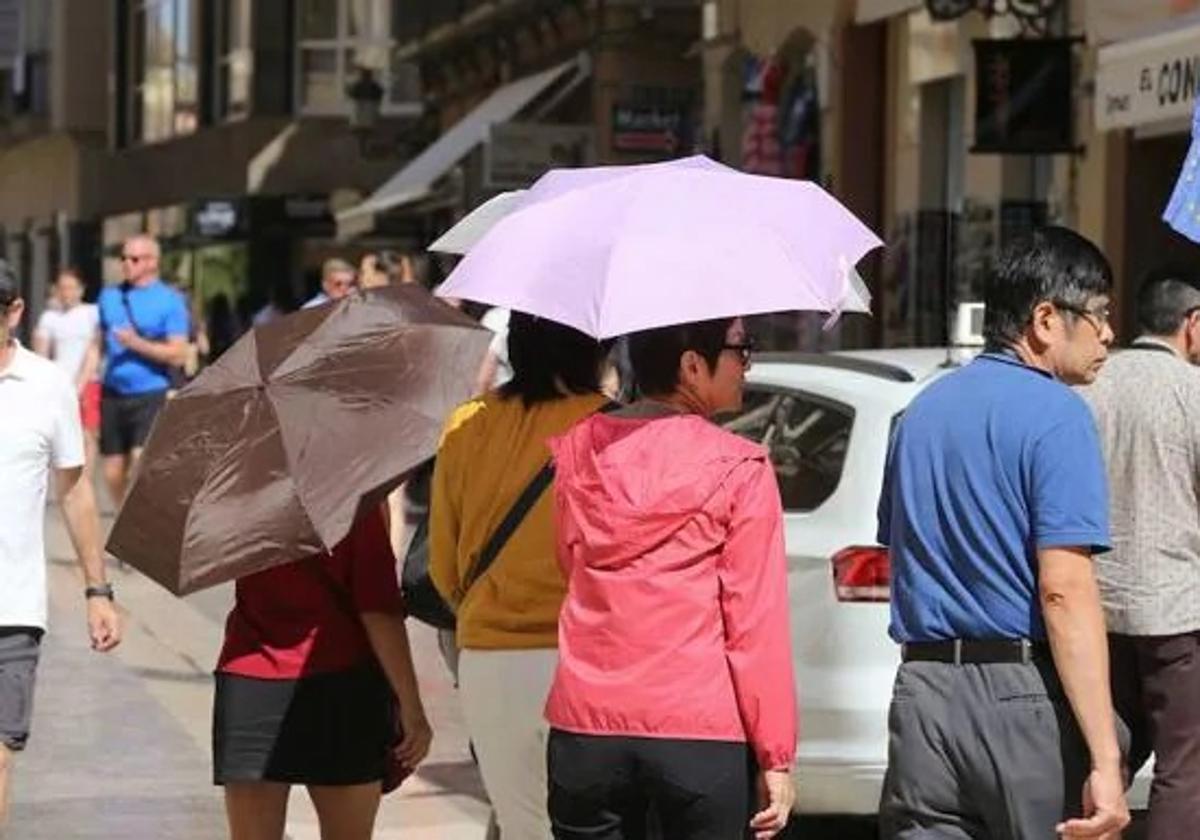 Turistas se protegen del sol en la capital