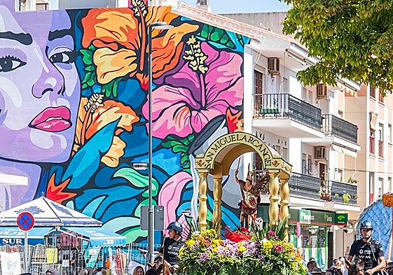 San Miguel Arcángel, a su paso por la plaza Vicente Aleixandre, junto al mural 'Ave del Paraíso', de Bosska.