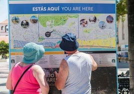 Dos turistas consultan un panel informativo sobre la ciudad.