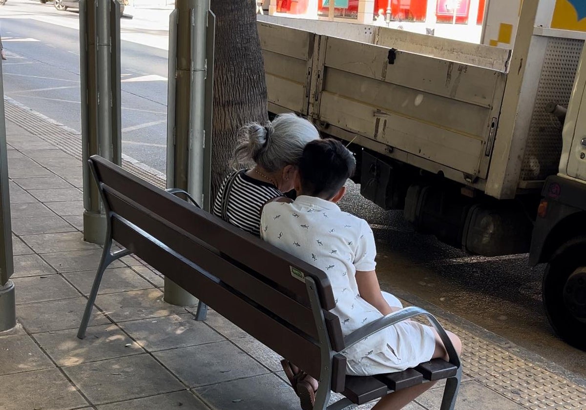 Una abuela y su nieto sentados en un banco en Alhaurín de la Torre.