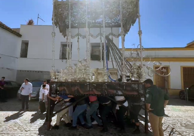 Malagueños bajo el paso de la Virgen del Patrocinio, durante un ensayo.