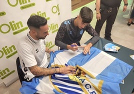 Víctor y Larrubia firman una bandera del Málaga en la tienda de 'Olín' de Fuengirola.