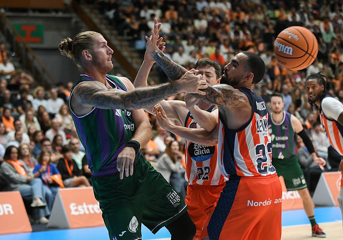 Osetkowski trata de pasar el balón ante la defensa de dos jugadores del Leyma Coruña.