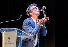 Atom Egoyan besa la estatuilla de la Niña de Benalmádena durante su reconocimiento en el Festival.