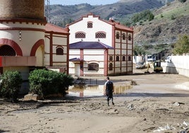 Un hombre intenta limpiar el barro de su zona de trabajo.