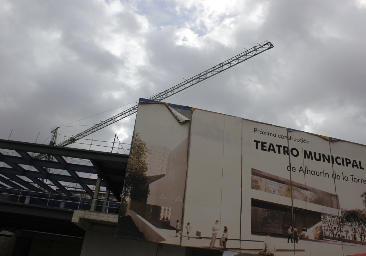 Cartel que anuncia la construcción del teatro, delante de la estructura del inmueble, que ya se aprecia.