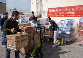 Miembros de la comunidad china de Málaga descargan cajas con las donaciones recibidas.