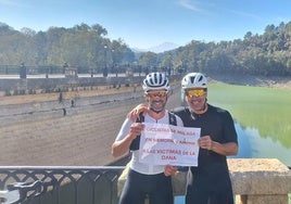 Miguel y Luis muestran una pancarta en apoyo a las víctimas de la DANA en Málaga.