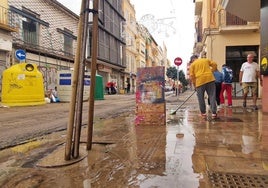 La calle y negocios de Carretería, afectados por el barrio que ha dejado la inundación de la vía.