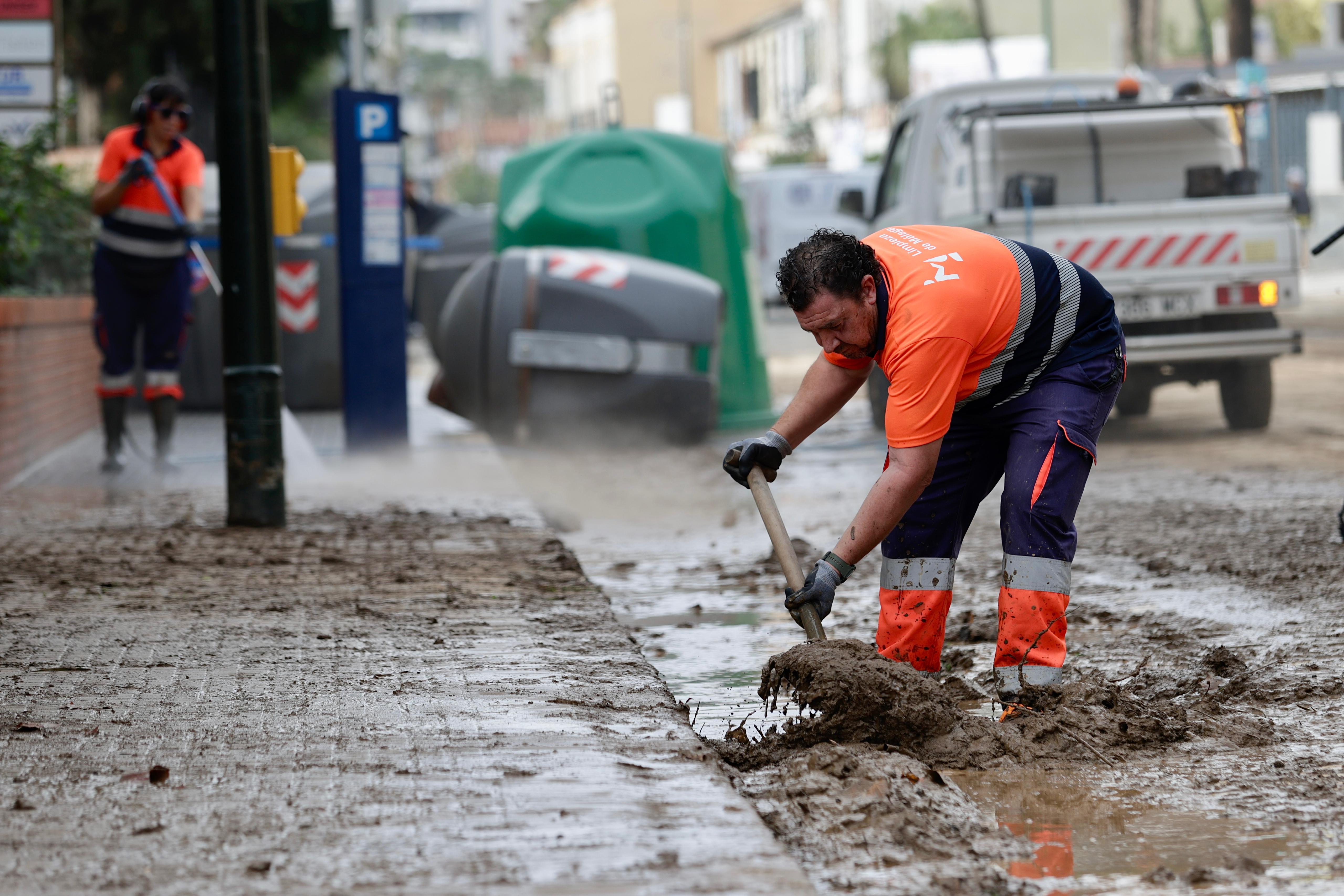 Operarios trabajan en la limpieza del paseo de Sancha y zona de El Limonar, donde quedan aún acumulados de barro y balsas de agua.