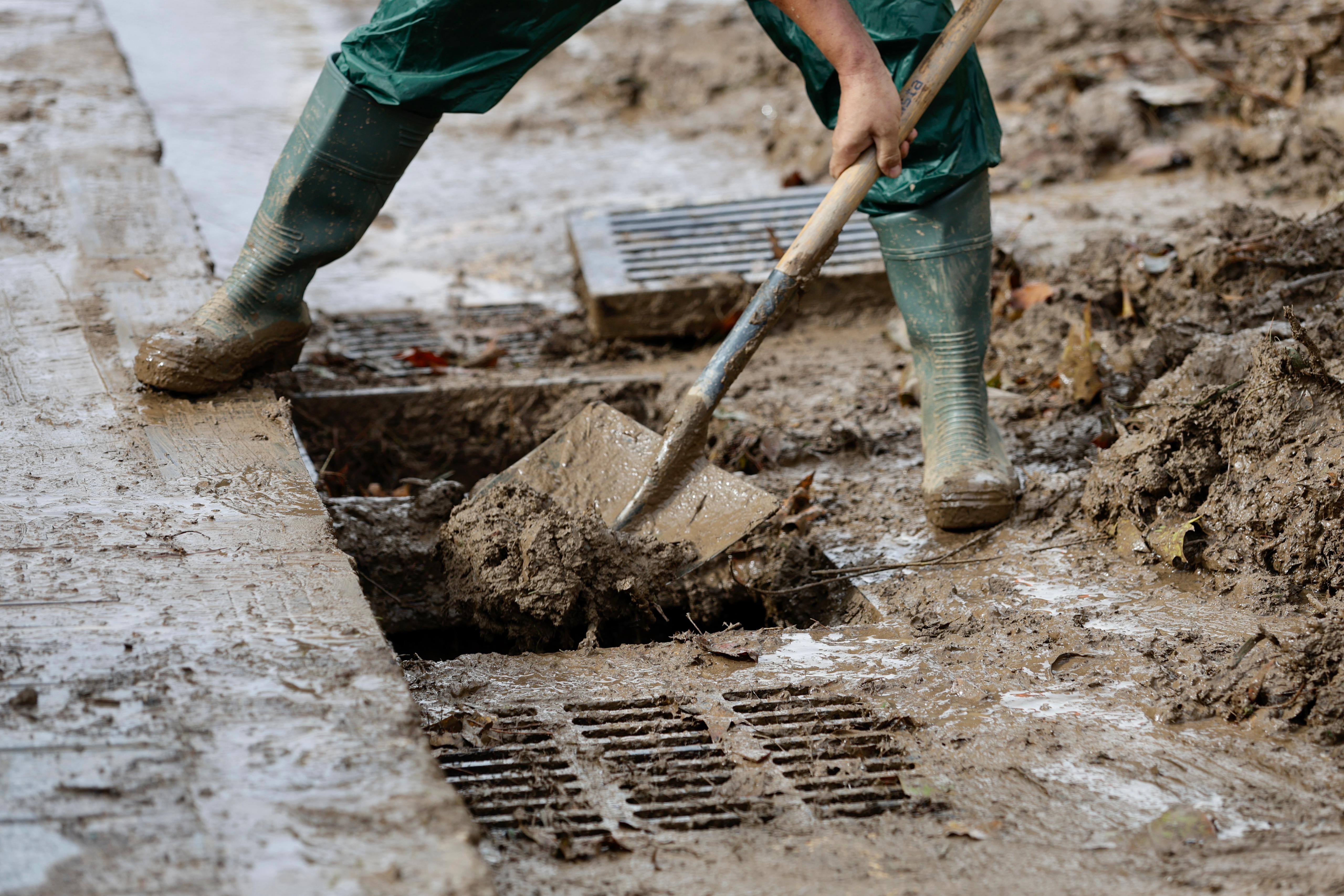 Operarios trabajan en la limpieza del paseo de Sancha y zona de El Limonar, donde quedan aún acumulados de barro y balsas de agua.