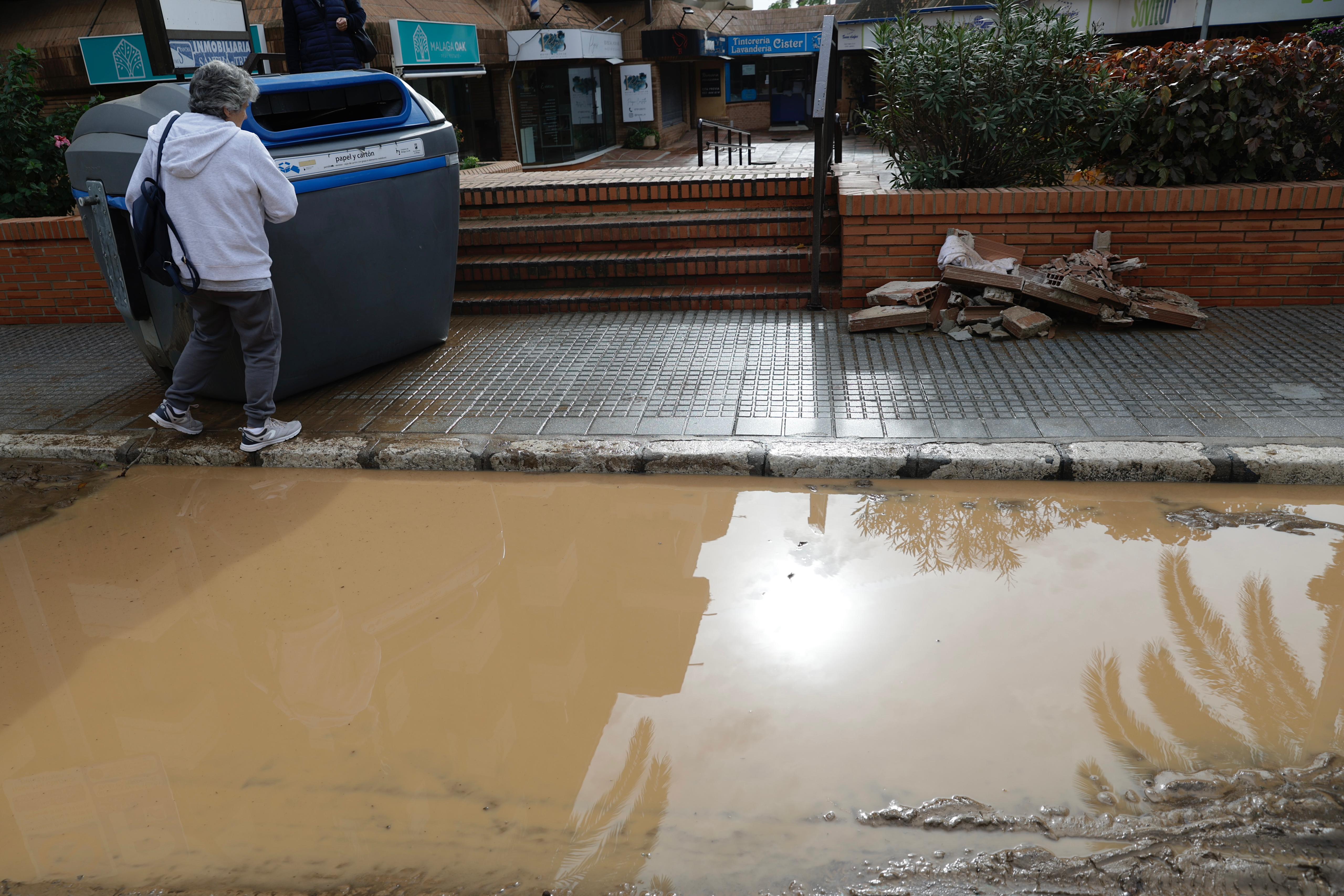 Operarios trabajan en la limpieza del paseo de Sancha y zona de El Limonar, donde quedan aún acumulados de barro y balsas de agua.