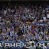 Aficionados del Málaga animan a su equipo en La Rosaleda.