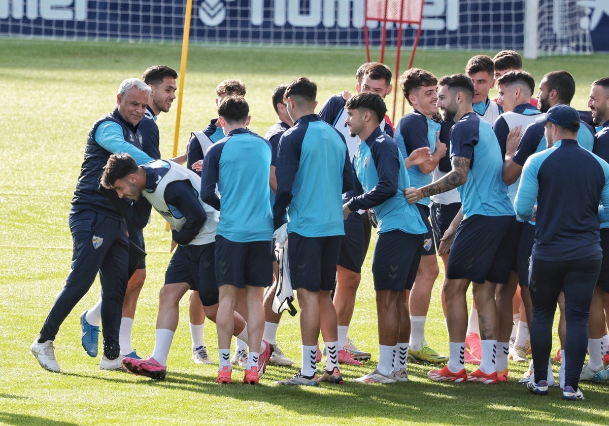 La plantilla del Málaga realiza el famoso 'pasillo de collejas' para felicitar a Puga por su cumpleaños en el último entrenamiento antes de viajar a Valencia.