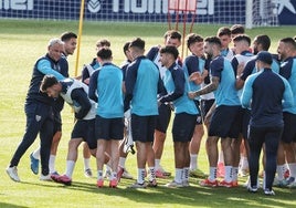 La plantilla del Málaga realiza el famoso 'pasillo de collejas' para felicitar a Puga por su cumpleaños en el último entrenamiento antes de viajar a Valencia.