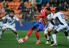 Tres jugadores del Marbella intentan frenar el avance atlético.