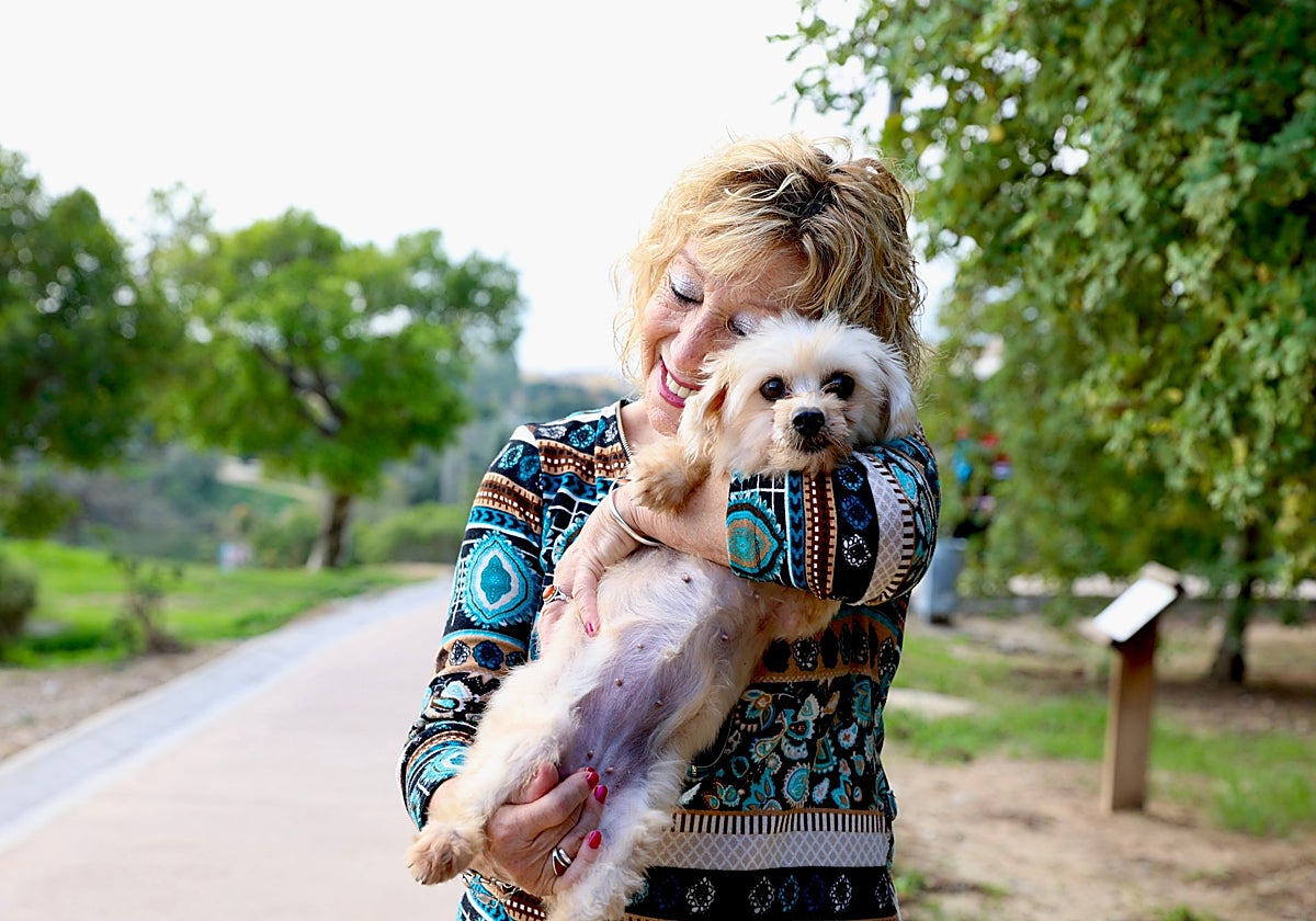 Paqui Téllez abraza a su perra Yari, recién adoptada, en un parque próximo a su casa.