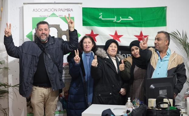 El grupo posa ante la nueva bandera oficial de Siria, la de la liberación.