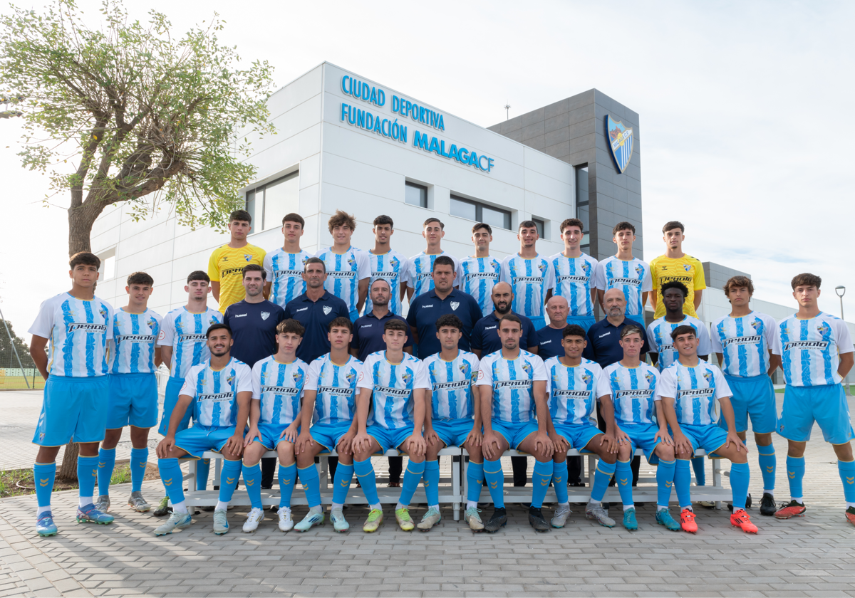 La plantilla y el cuerpo técnico del Juvenil A del Málaga posa delante de La Academia.