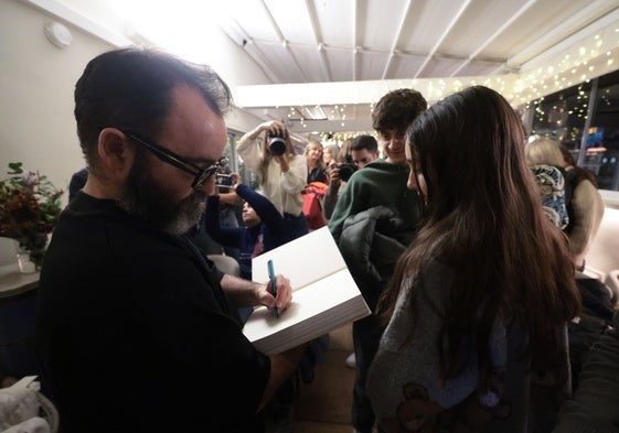 Javier Calleja, firmando un catálogo de sus obras.