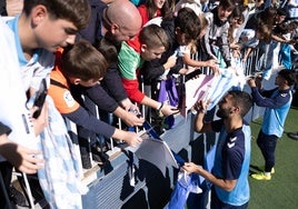 Galilea saluda y firma a un aficionado del Málaga en el entrenamiento de puertas abiertas.