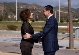 María Jesús Montero y Juanma Moreno se saludan a la llegada del presidente al acto.