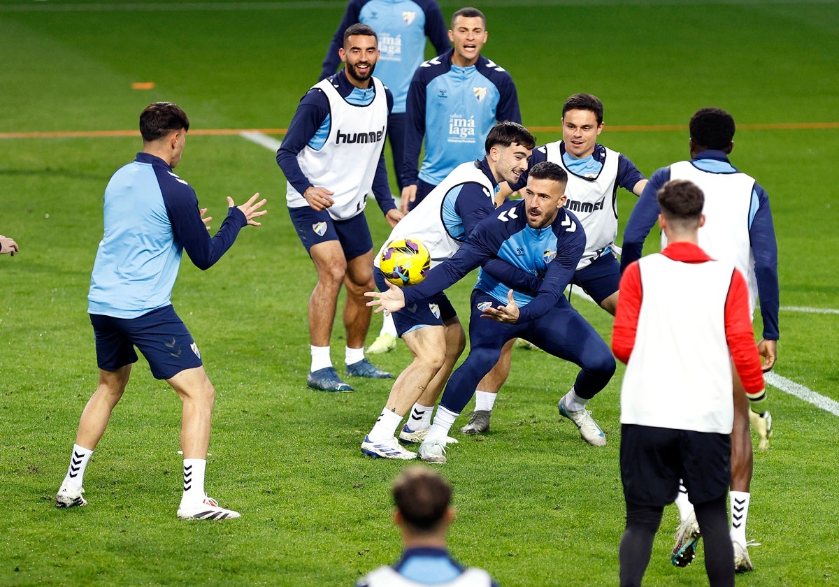 Dioni y el resto de sus compañeros realizan un ejercicio con las manos en un entrenamiento reciente en La Rosaleda.