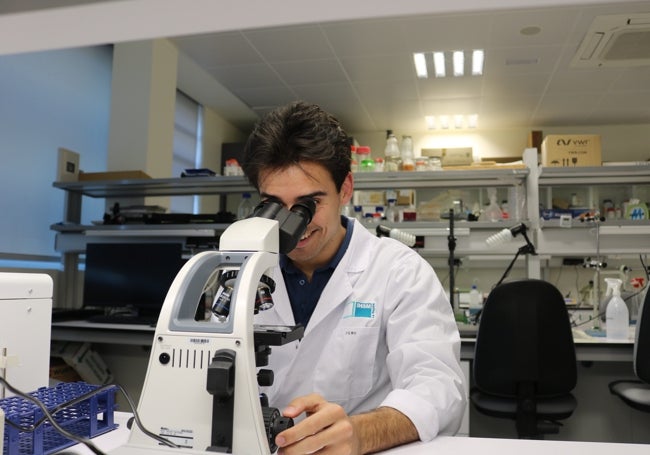 Jerónimo Coto, investigador en la UMA, en su zona de trabajo frente a microscopio.