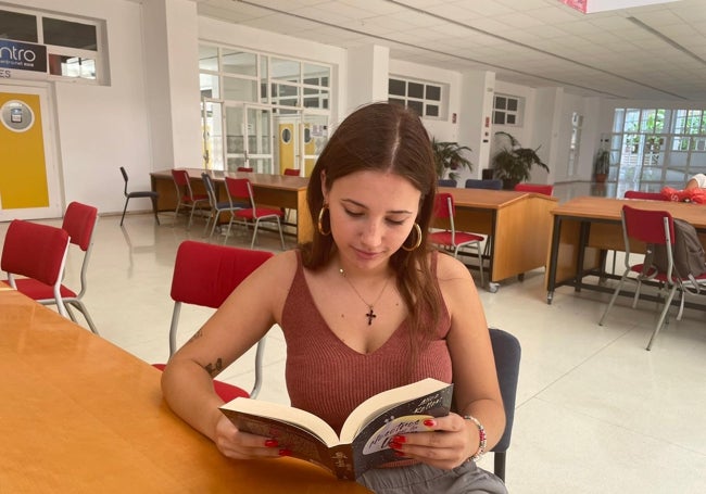 Andrea Díaz, alumna de Periodismo, con 'Nosotros en la luna', de Alice Kellen, en la cafetería.