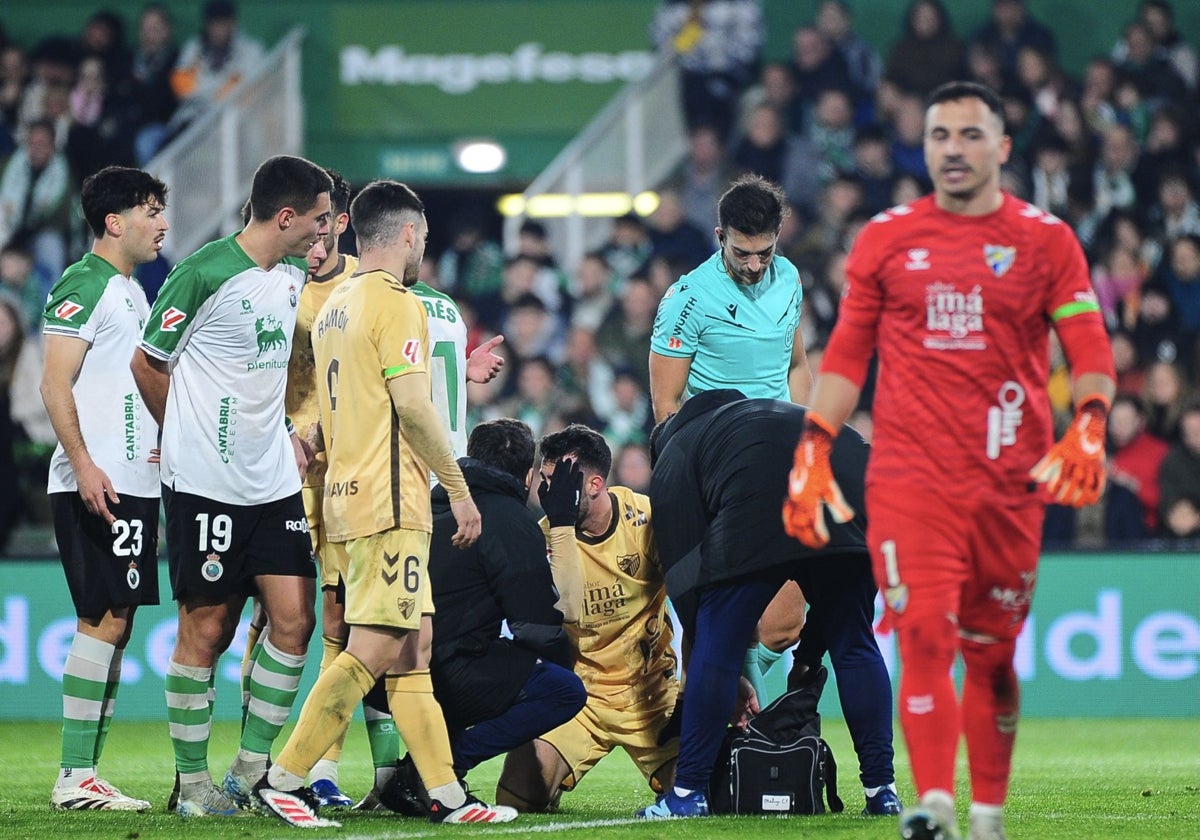 El responsable médico del Málaga atiende a Puga tras un fuerte golpe en la cabeza con Castro en el segundo tiempo del duelo de anoche.