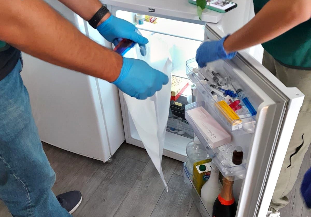 Agentes inspeccionan el frigo de uno de los centros, donde hay desde inyectables hasta champán.