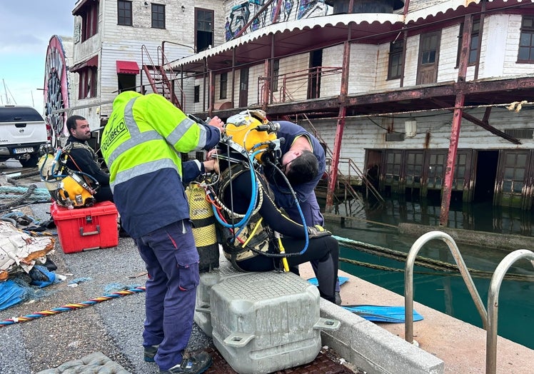 Buzos encargados de instalar las barreras anticontaminación.