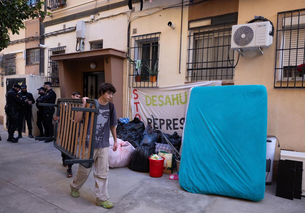 Vecinos ayudan a la familia desahuciada a bajar sus enseres personales.