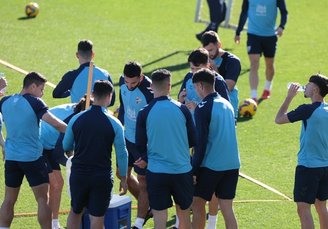 Los jugadores del Málaga se hidratan en la sesión de entrenamiento de este miércoles.