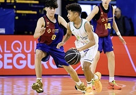 Shokrinia trata de avanzar defendido por un jugador del Barcelona.