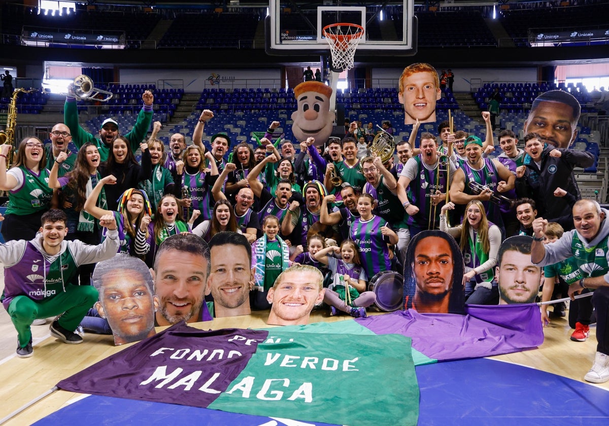 La banda de Los Mihitas y un grupo de aficionados del Unicaja posa en la pista del Carpena para SUR.