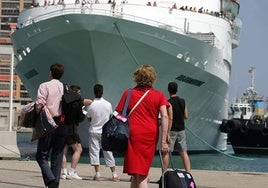 Una crucerista se dirige hacia el barco en el que disfrutará de sus vacaciones.