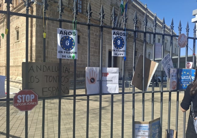 Carteles de protesta reflejan el rechazo a las oposiciones, frente al Parlamento.