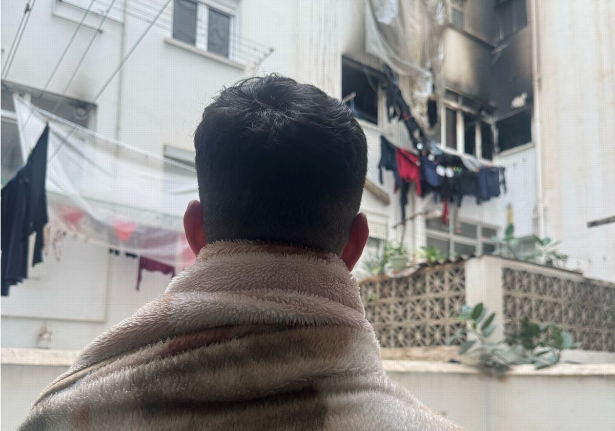 Mohamed observa desde su patio el piso incendiado de sus vecinos.