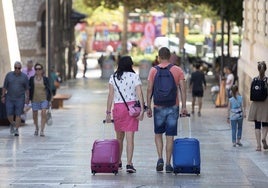 Turistas se dirigen por el centro de la ciudad a su alojamiento.