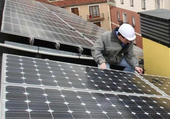 Un operario instala una placa fotovoltaica.