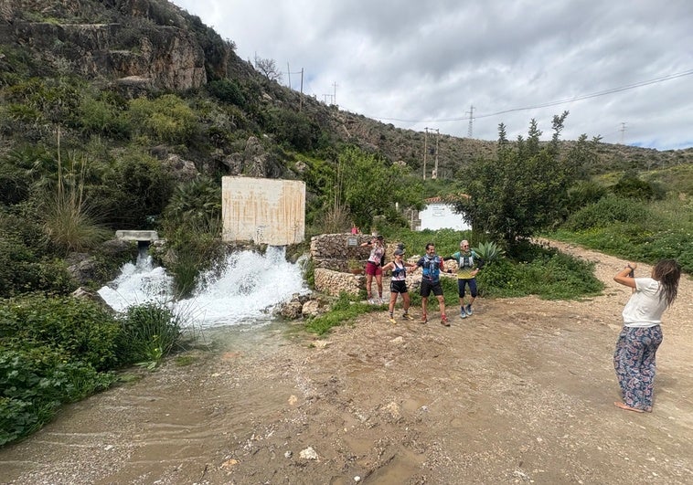 Un grupo de deportistas, este domingo fotografiándose junto al Nacimiento de Maro, de donde sale el agua que se precipita por la Cascada Grande.