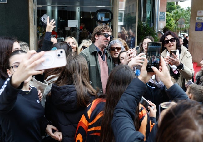 Los fans, en la puerta del AC Málaga Palacio, rodean al actor Iván Massagué para hacerse una fotografía con él.