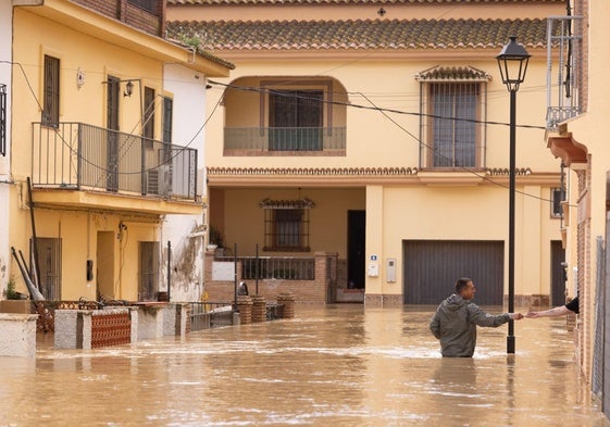 Un vecino con el agua por la cintura en la barriada Santa Ana de Cártama.