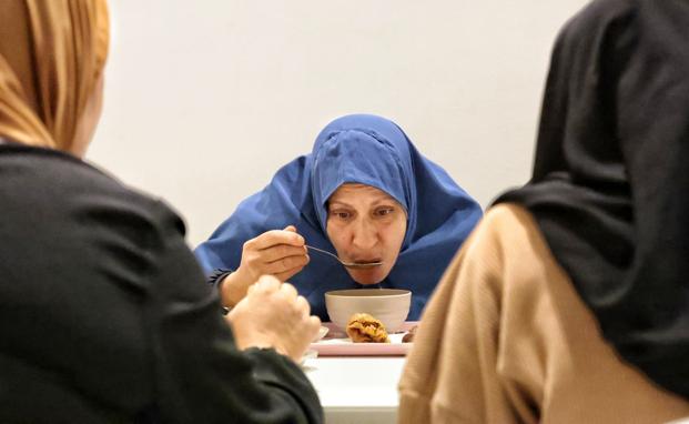 Una mujer, tomando la harira, una sopa típica.