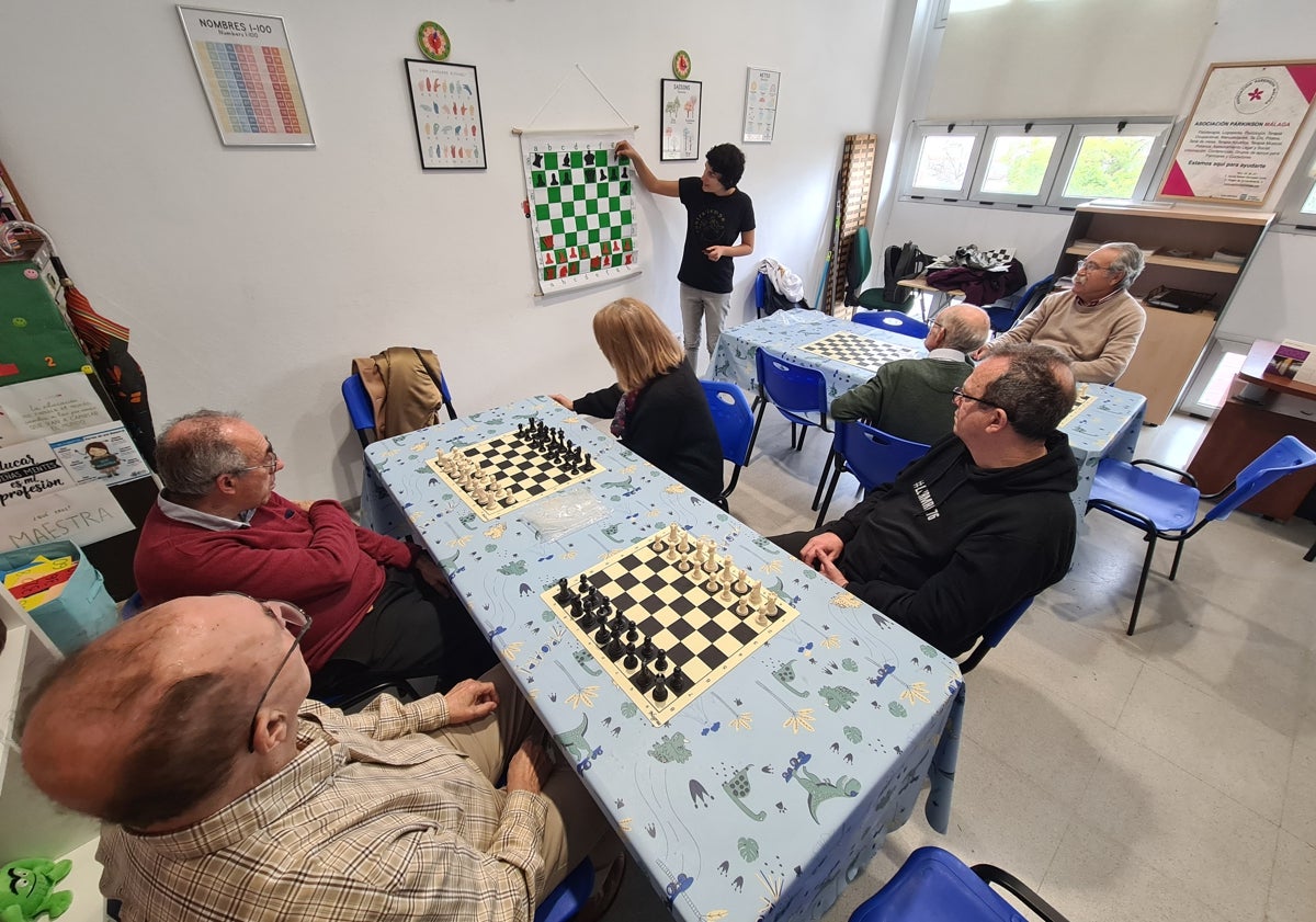 Imagen principal - Clases de ajedrez como parte de las terapias que se desarrollan en la Asociación del Párkinson de Málaga.