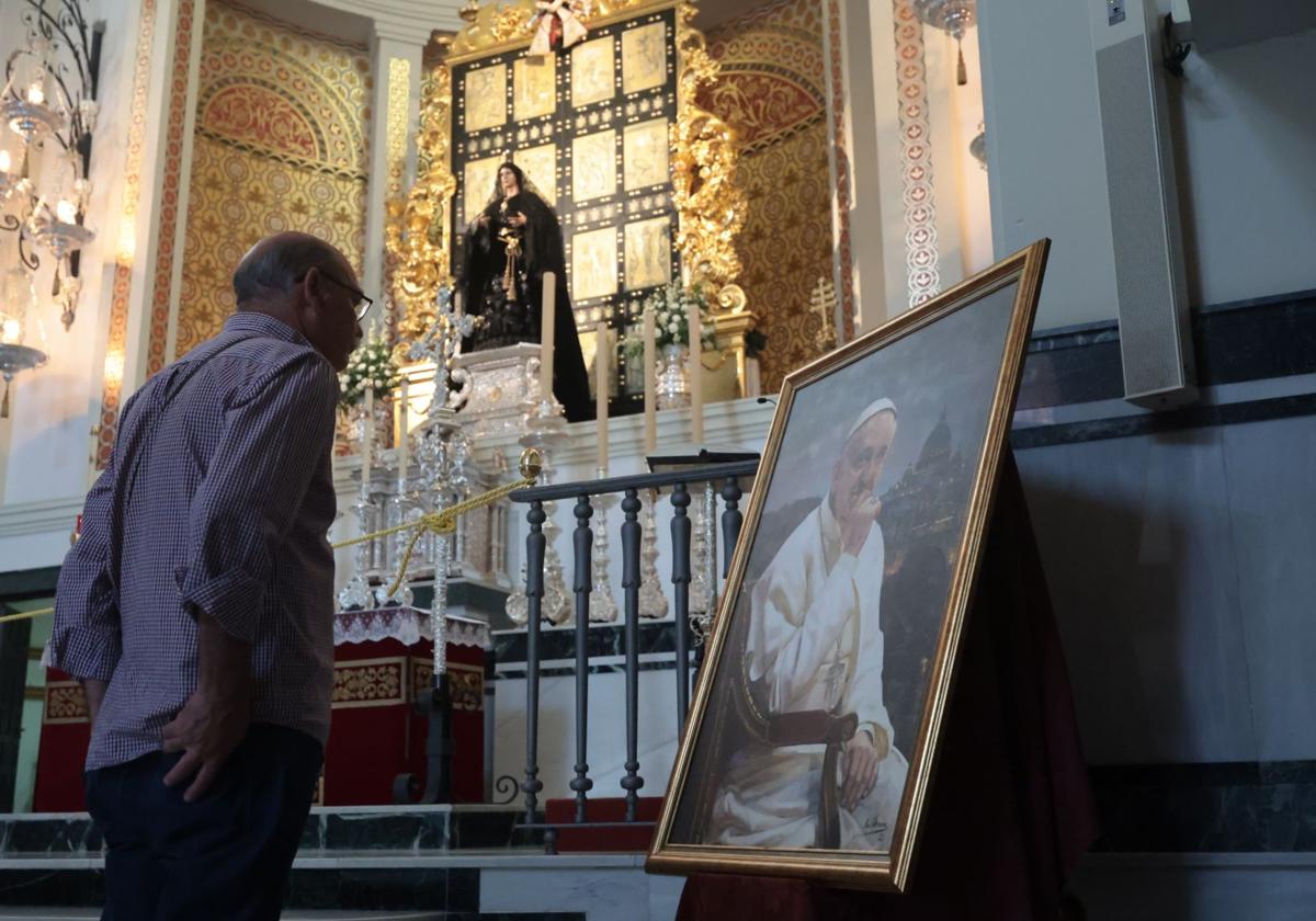 La Esperanza, ataviada de luto, en su basílica junto a un cuadro con la imagen del pontífice.